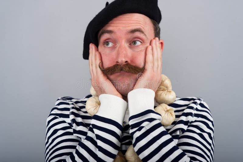 This is a character portrait of a Frenchman wearing a blue and white hooped top - BRETTON STYLE. He is wearing a beret, a garlic necklace and has his hands clasping his cheeks in an expression of 'Oh well'. This is a character portrait of a Frenchman wearing a blue and white hooped top - BRETTON STYLE. He is wearing a beret, a garlic necklace and has his hands clasping his cheeks in an expression of 'Oh well'