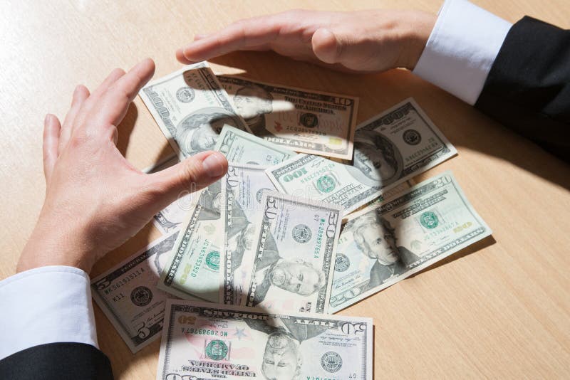 Oigenkännlig affärsman som rymmer pappers- pengar/dollar royaltyfria foton Oigenkännlig affärsman som rymmer pappers- pengar/dollar royaltyfria foton