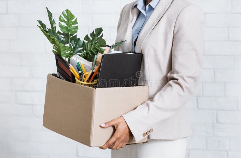 Unrecognizable black woman holding box of personal belongings, leaving office after losing her job, closeup of hands. Economic crisis and unemployment during covid-19 epidemic. Unrecognizable black woman holding box of personal belongings, leaving office after losing her job, closeup of hands. Economic crisis and unemployment during covid-19 epidemic