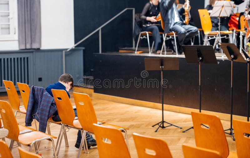 Oigenkännlig pojke som witing för att orkester ska börja deras lek arkivbilder Oigenkännlig pojke som witing för att orkester ska börja deras lek arkivbilder
