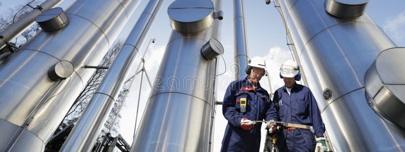 Di petrolio e di gas operai con grandi tubi di gas costruzione in background, vista panoramica.