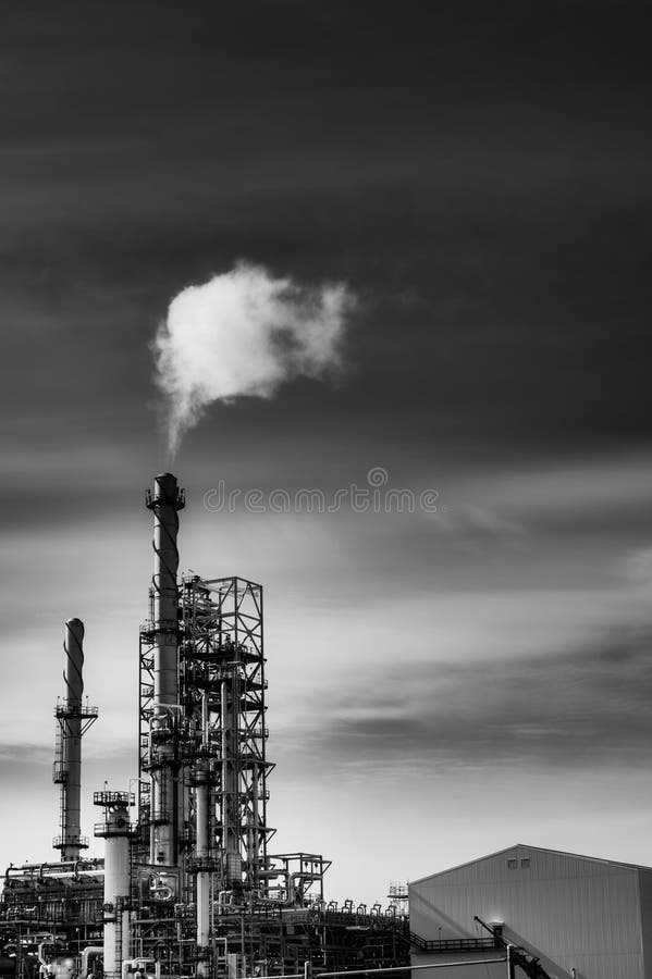 Oil refinery with smoke from the chemney.Black and white with high contrast.