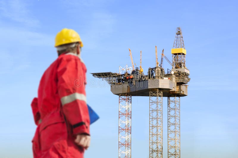 Roughneck (fuori fuoco), guardando un enorme piattaforma petrolifera in fase di costruzione.