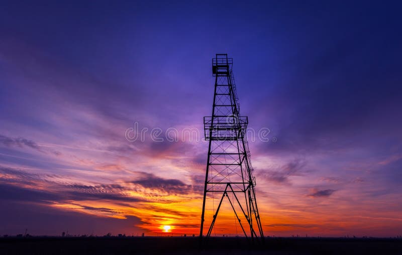 Oil rig profiled on dramatic sunset sky