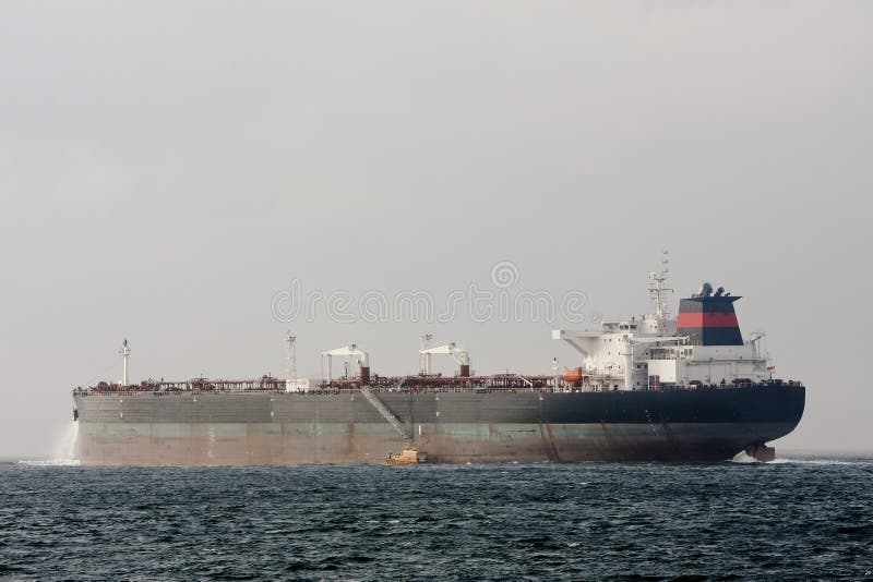 Oil supertanker ship at sea with pilot boat.