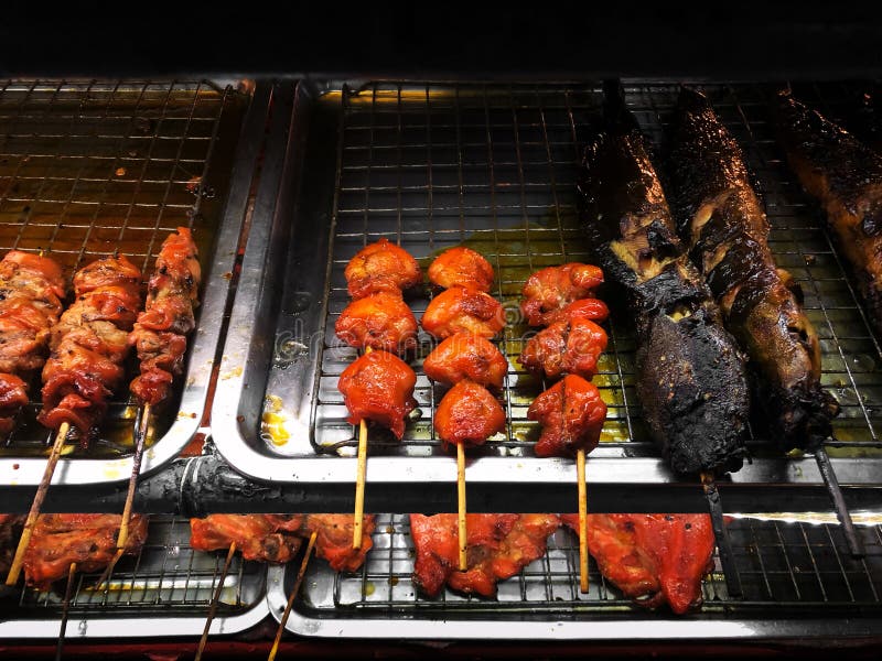 Oily grill chicken and catfish skewer - unhealthy street food stock images Oily grill chicken and catfish skewer - unhealthy street food stock images