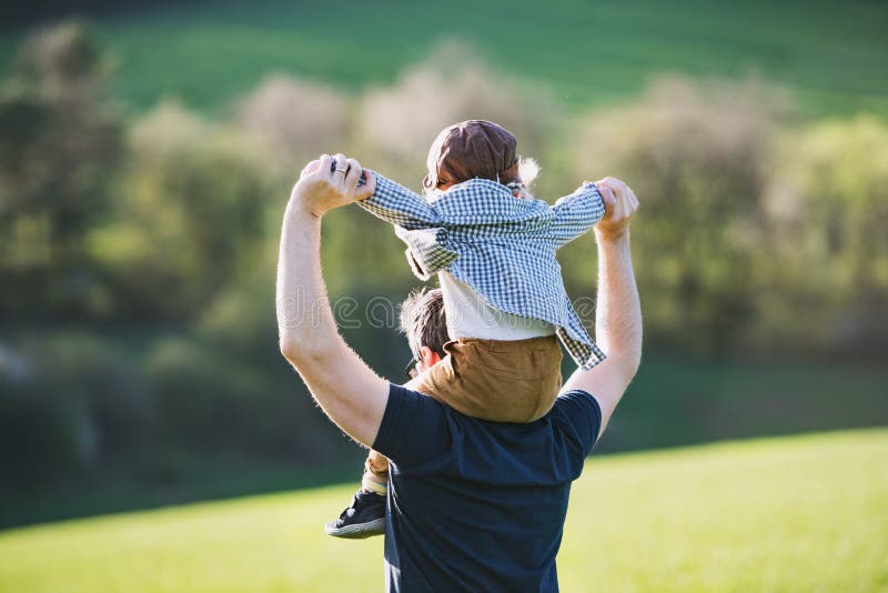 Ojciec daje berbecia syna piggyback przejażdżce outside w wiosny naturze zdjęcie royalty free Ojciec daje berbecia syna piggyback przejażdżce outside w wiosny naturze zdjęcie royalty free