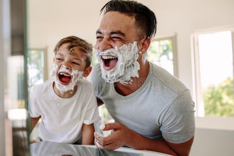 Ojciec i syn ma zabawę w łazience podczas gdy goljący