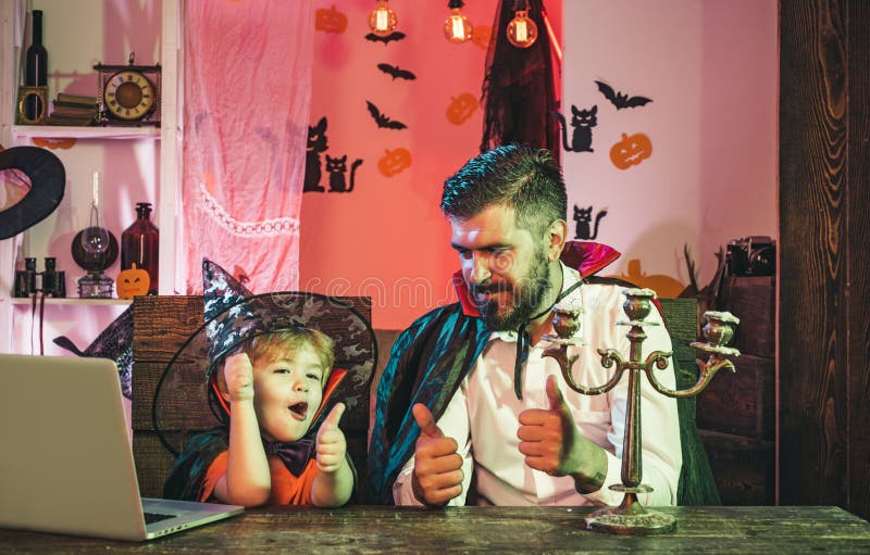 Ojciec i syn są zadowoleni z zakupów online Zadowolona rodzina w pobliżu notebooka Jesienne święta i Halloween zdjęcia stock Ojciec i syn są zadowoleni z zakupów online Zadowolona rodzina w pobliżu notebooka Jesienne święta i Halloween zdjęcia stock