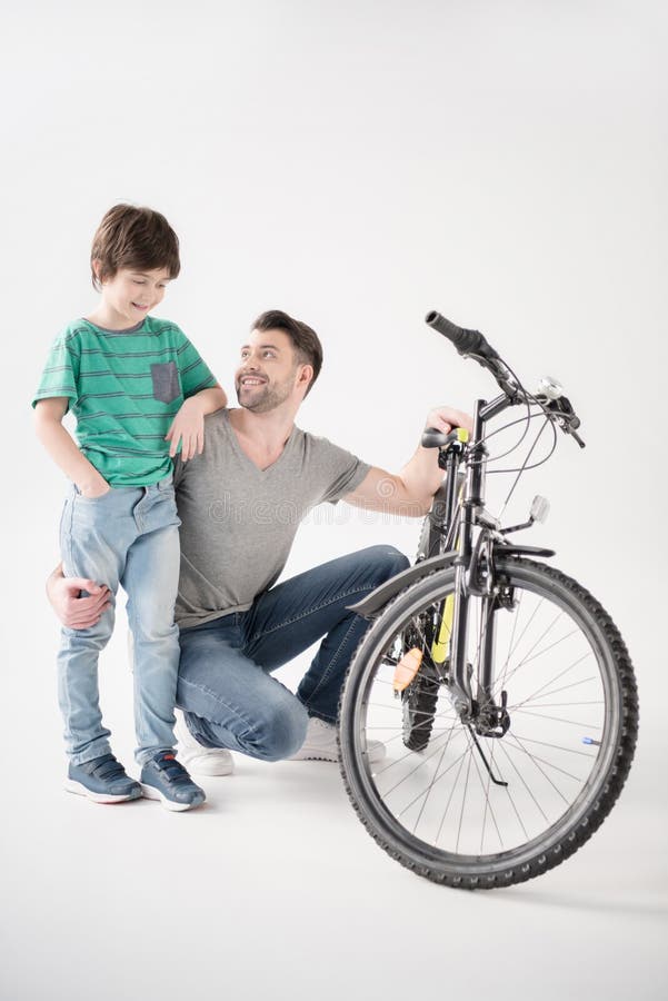 Szczęśliwy ojciec i syn z nowym bicyklem na bielu