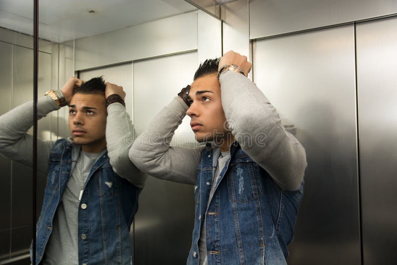 Okaleczający młody człowiek desperacki w zablokowanej windzie