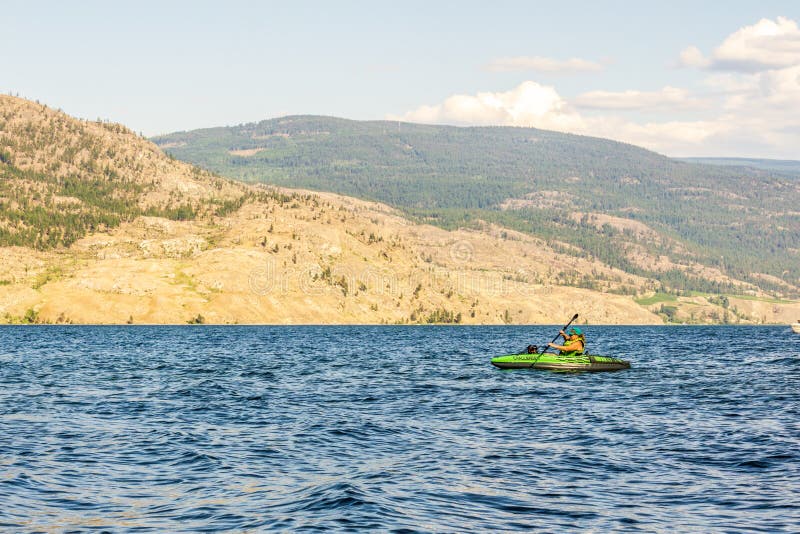 Okanagan dolina Kanada, Sierpień, - 05, 2018: Osoba kayaking na nadmuchiwanym kajaku w Okanagan jeziorze Kanada BC zdjęcia royalty free Okanagan dolina Kanada, Sierpień, - 05, 2018: Osoba kayaking na nadmuchiwanym kajaku w Okanagan jeziorze Kanada BC zdjęcia royalty free