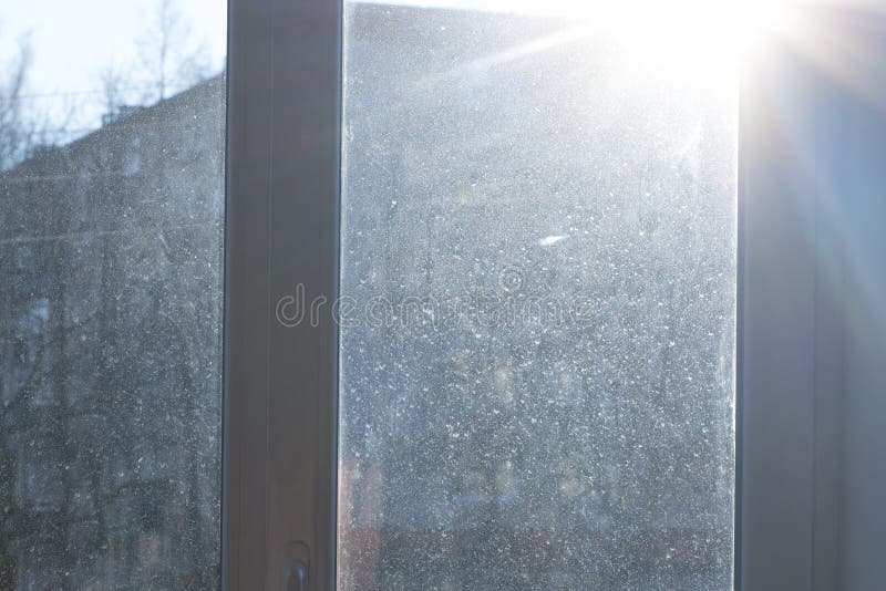 Okno z brudnym i zakurzonym szkłem w świetle dziennym