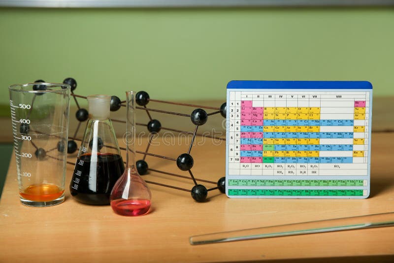 composition on the subject of chemistry. periodic table of chemical elements near chemical flasks and crystalline lattice model. composition on the subject of chemistry. periodic table of chemical elements near chemical flasks and crystalline lattice model.