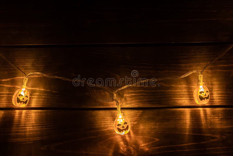 Okropny symbol Halloween - Garland Jack-o-lantern z trzema pomarańczowymi dyniami Straszna głowa dyni świecąca w ciemności obrazy royalty free Okropny symbol Halloween - Garland Jack-o-lantern z trzema pomarańczowymi dyniami Straszna głowa dyni świecąca w ciemności obrazy royalty free