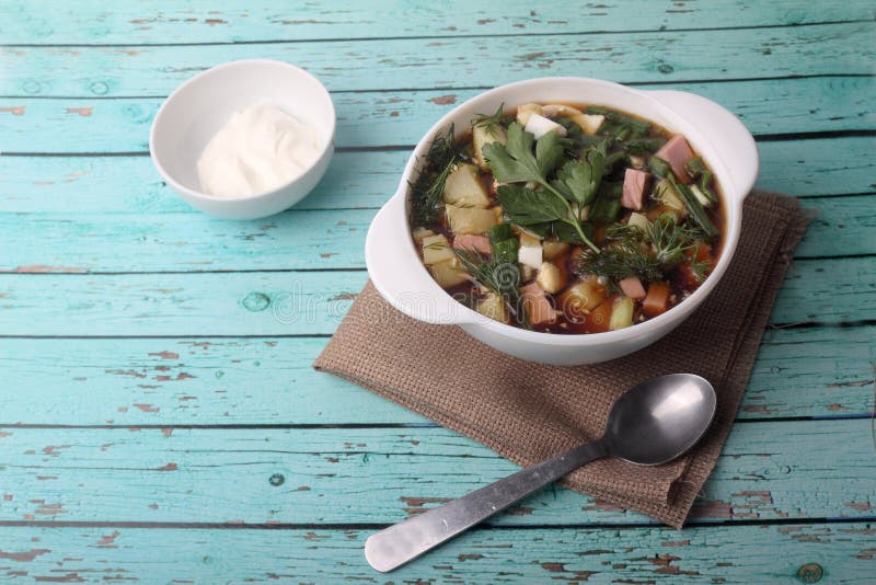 Okroshka - cold vegetable soup - in a bowl on blue wooden background