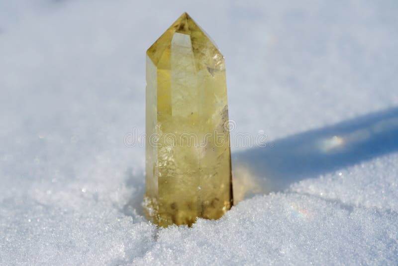 Okrzesany Citrine Kwarcowy Generatorowy punkt od Brazylia na białym śniegu zdjęcie stock Okrzesany Citrine Kwarcowy Generatorowy punkt od Brazylia na białym śniegu zdjęcie stock