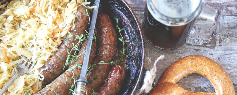 Oktoberfest food. Bavarian sausages and sauerkraut in a pan.