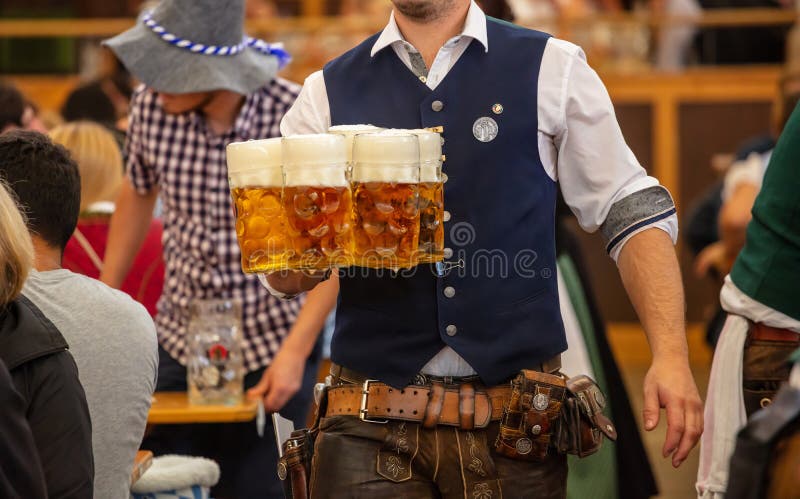 Oktoberfest, Munich, Alemanha Garçom que serve cervejas, opinião do close up imagem de stock royalty free Oktoberfest, Munich, Alemanha Garçom que serve cervejas, opinião do close up imagem de stock royalty free