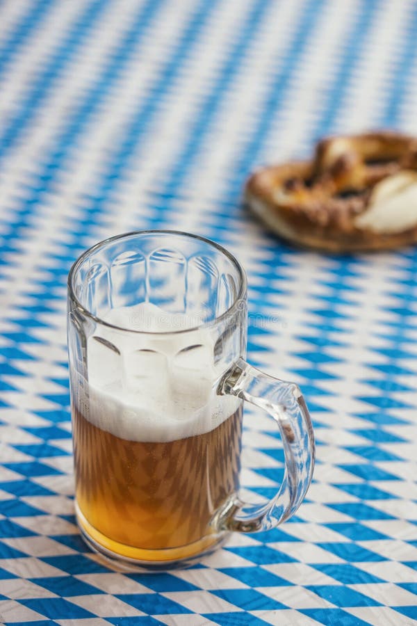 Oktoberfest: Pretzel e cerveja na toalha de mesa bávara imagens de stock Oktoberfest: Pretzel e cerveja na toalha de mesa bávara imagens de stock