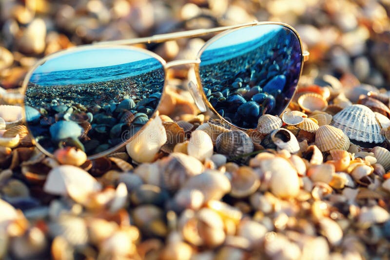 Okulary przeciwsłoneczne na plaży z odbiciem morskim