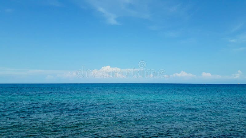 Olas de calma del océano azul y cielo azul en un día de verano imagen de archivo libre de regalías