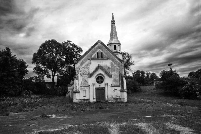 Old abandoned church against dramatic dark sky, black & white