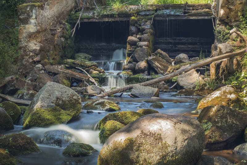 Old, abandoned water mill with water streams and little waterfalls