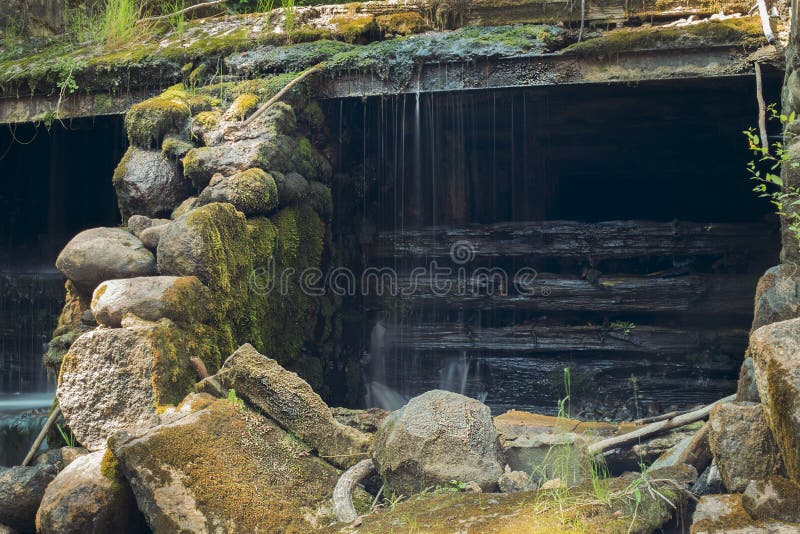 Old, abandoned water mill with water streams and little waterfalls