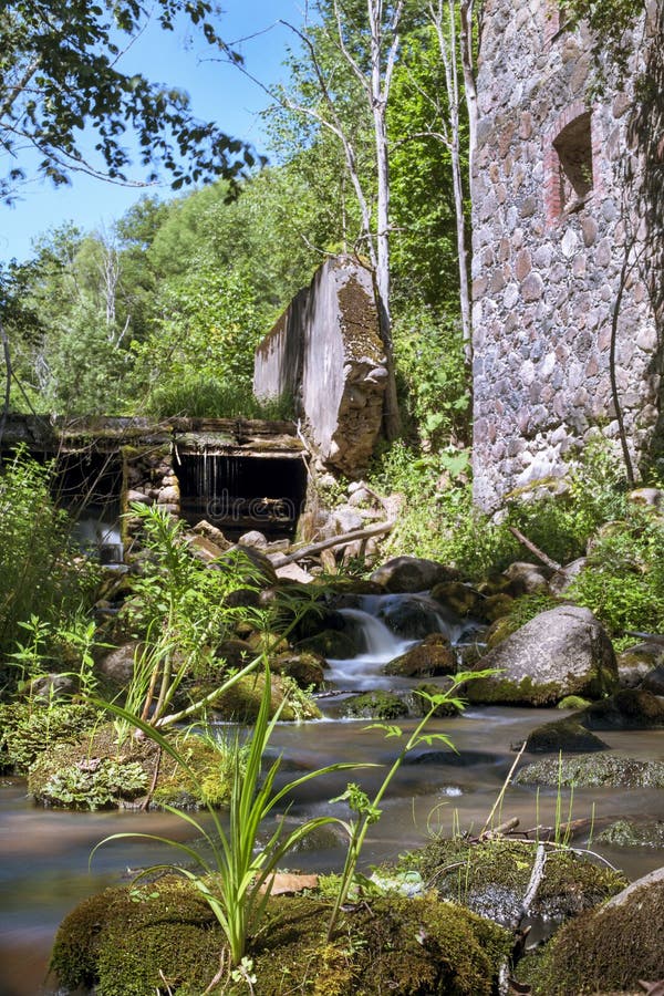 Old, abandoned water mill with water streams and little waterfalls