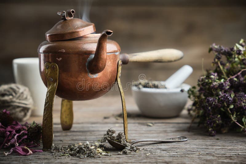 Old antique boiling teapot, mortar, dry coneflowers and thyme bunch