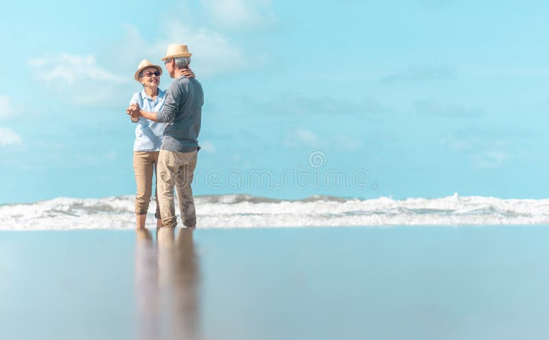 An old Asian couple is dancing by the sea, the atmosphere is good stock photos An old Asian couple is dancing by the sea, the atmosphere is good stock photos