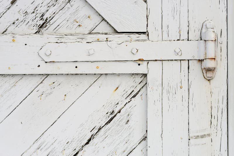 A white painted hinge to an old barn door. A white painted hinge to an old barn door.