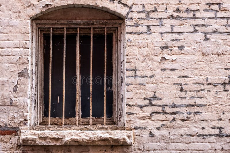 Old barred window and decaying brick work stock foto's