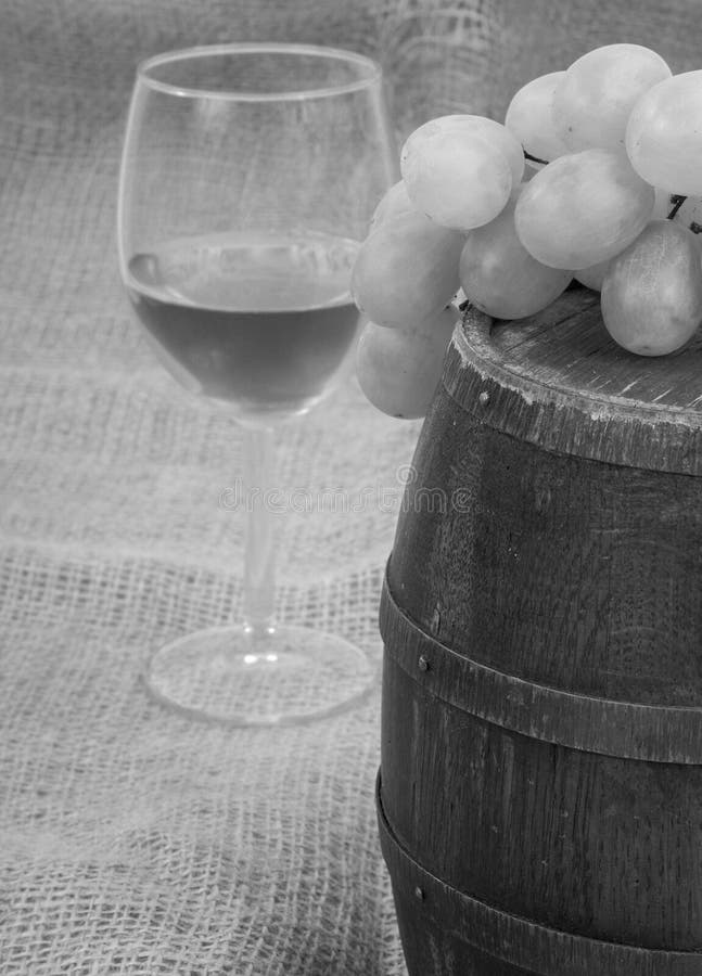 Old barrel with glass of wine and grapes black & white tone