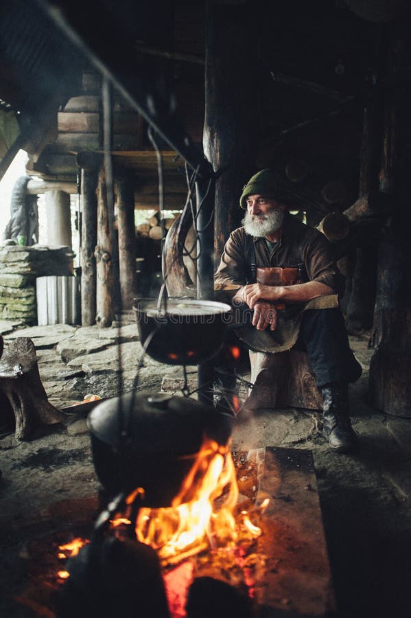 Old bearded forester with axe near wooden hut stock image Old bearded forester with axe near wooden hut stock image