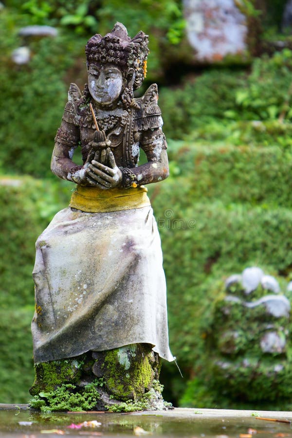 Old beautiful stone Balinese statue stock photography