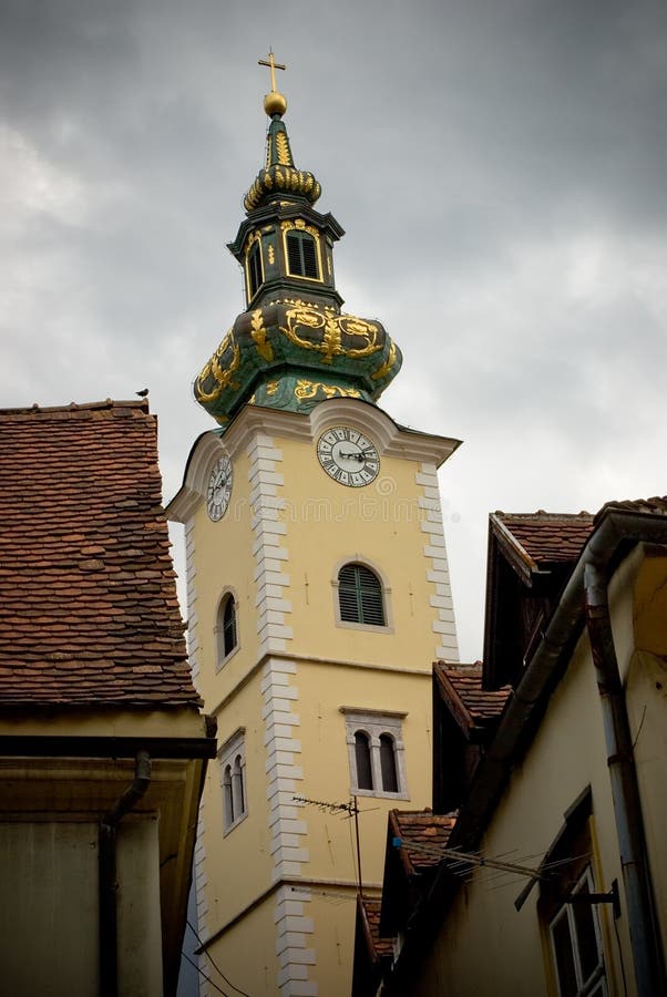 Old bell tower with clock in narrow streets
