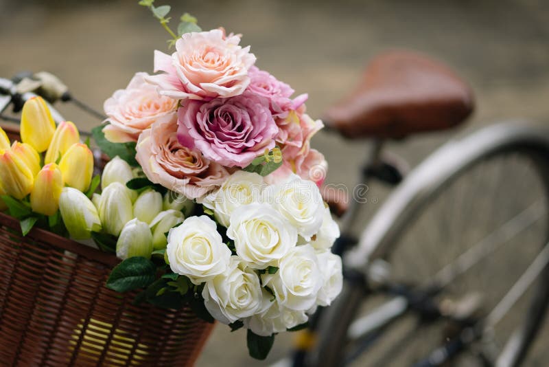 Old bicycle with flowers in plastic basket on a rainy autumn day