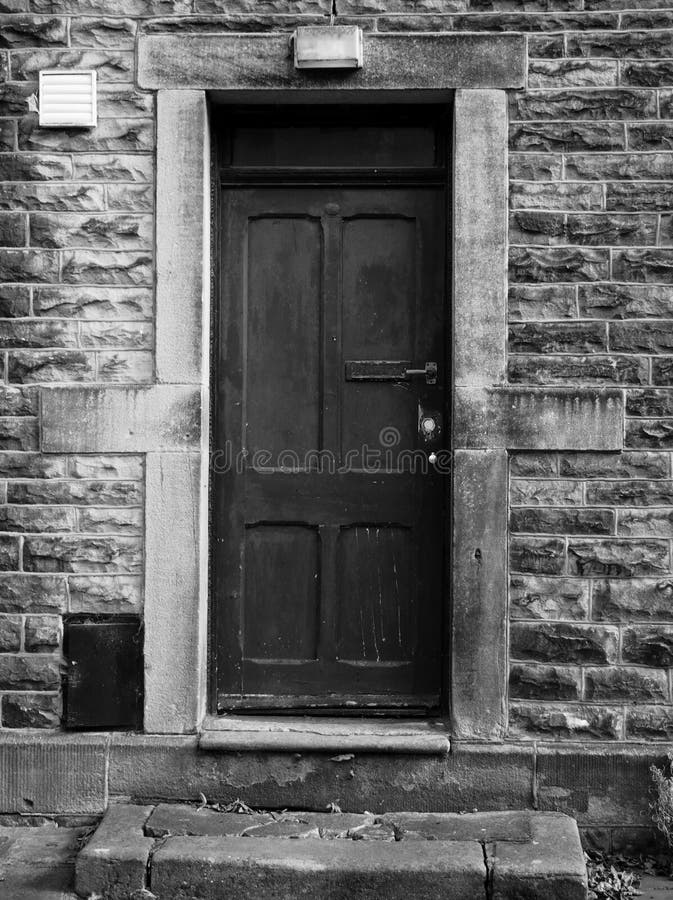 Old black door with faded and flaking paintwork