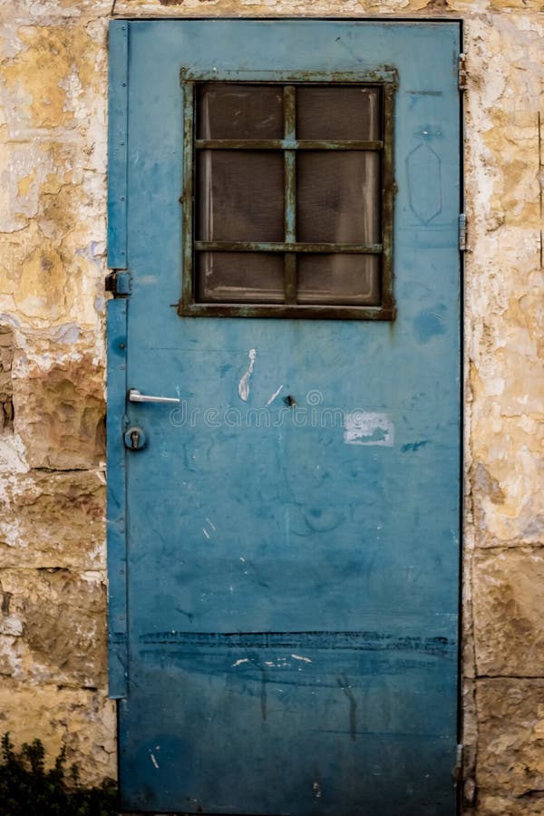 Old blue metal dirt door with window and rusty metal lockas a beautiful vintage background royalty free stock photo Old blue metal dirt door with window and rusty metal lockas a beautiful vintage background royalty free stock photo