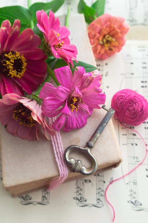 Old book with vintage key and pink flowers zinnia stock photography Old book with vintage key and pink flowers zinnia stock photography