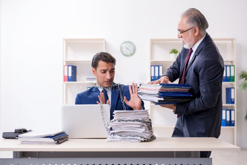 Old boss and young male employee in the office stock photos