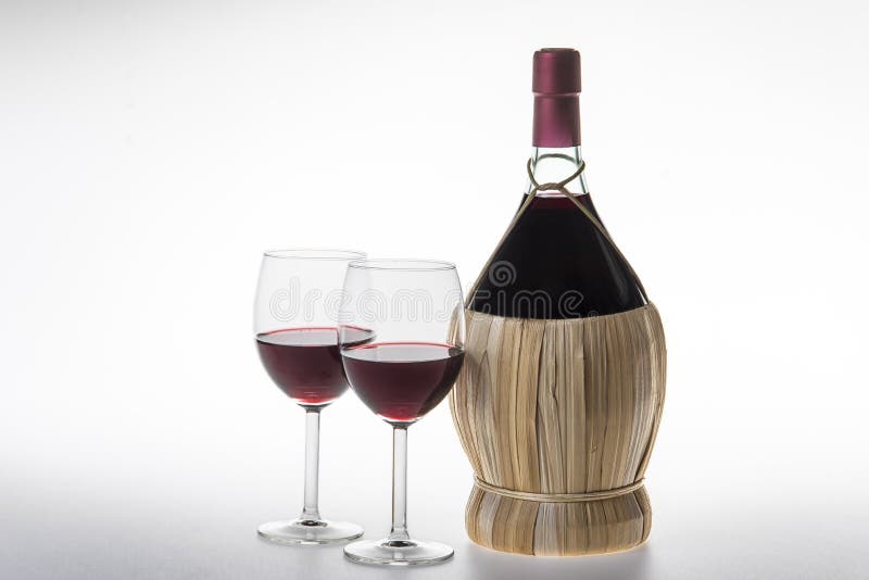 Una bottiglia,, un due occhiali da vino rosso su bianco.