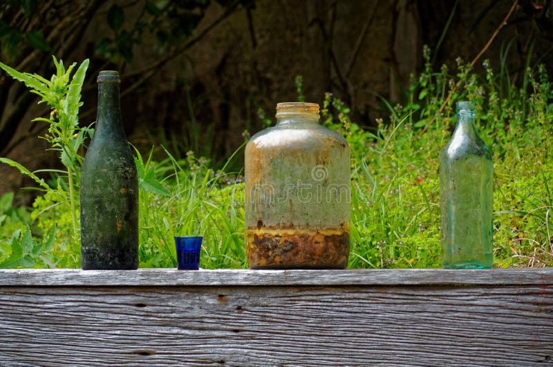Old bottles and jars discarded on a wooden garden fence royalty free stock photo Old bottles and jars discarded on a wooden garden fence royalty free stock photo