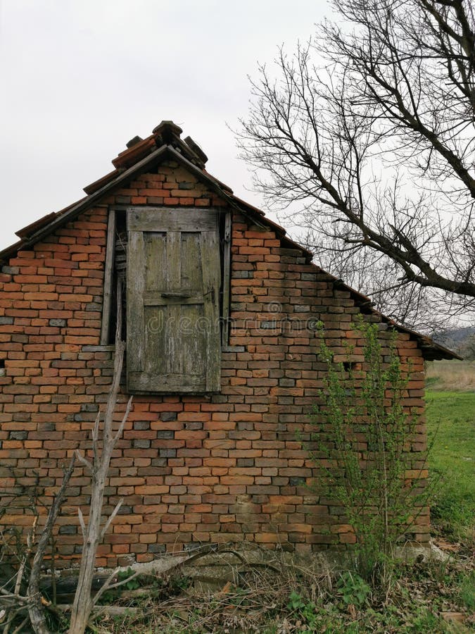 Old brick house with a wooden door in the attic royalty free stock photography Old brick house with a wooden door in the attic royalty free stock photography