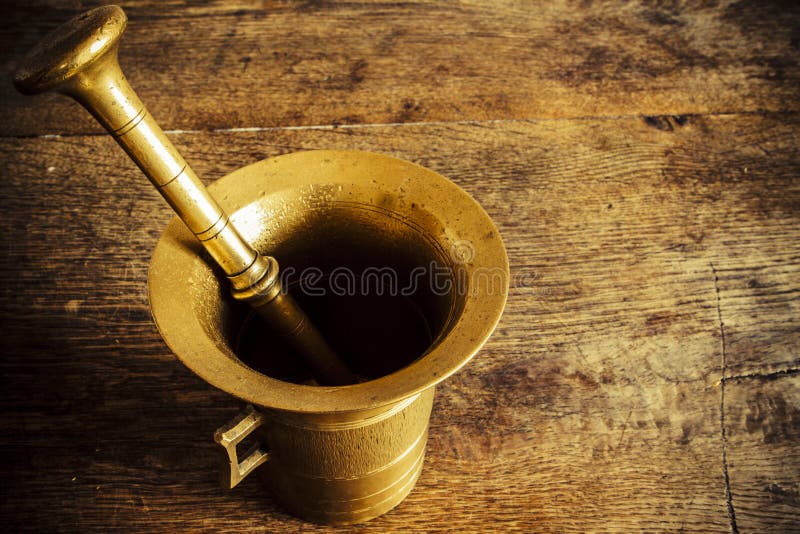 Old bronze mortar with pestle on wootden table