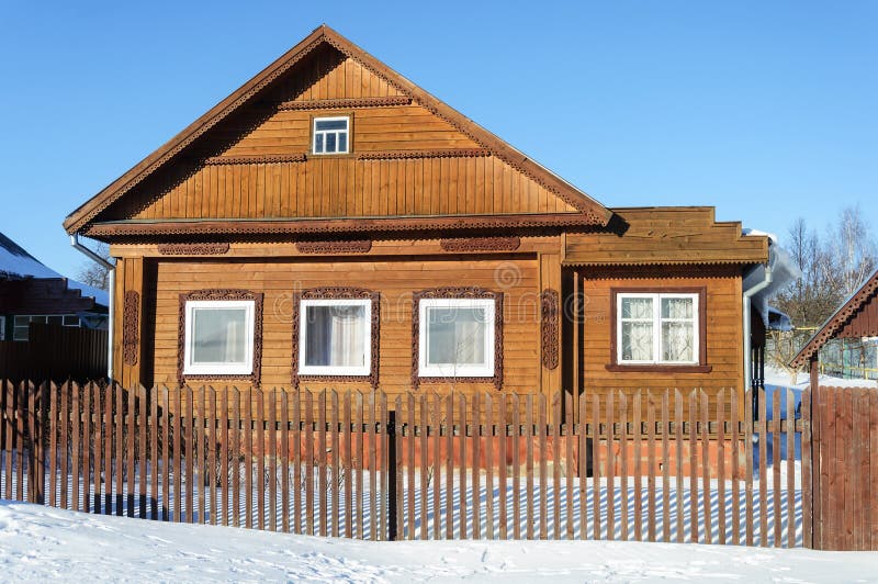 Old brown wooden house in winter time