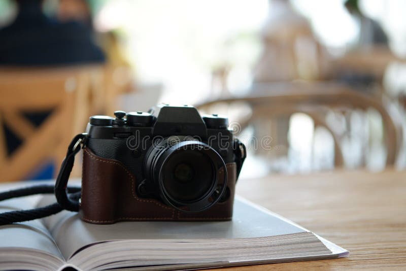 Old camera on book on table cafe background stock image