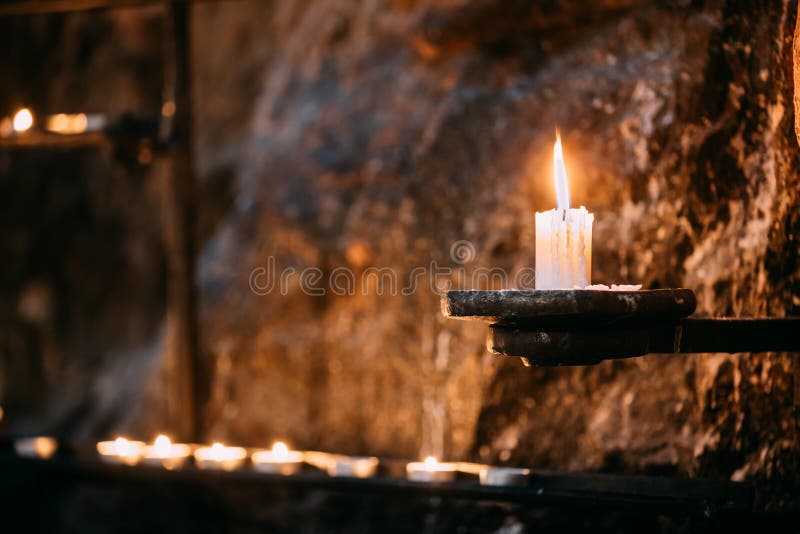 Old Candle In Church. Candle Light Flame Near Ancient Wall royalty free stock images